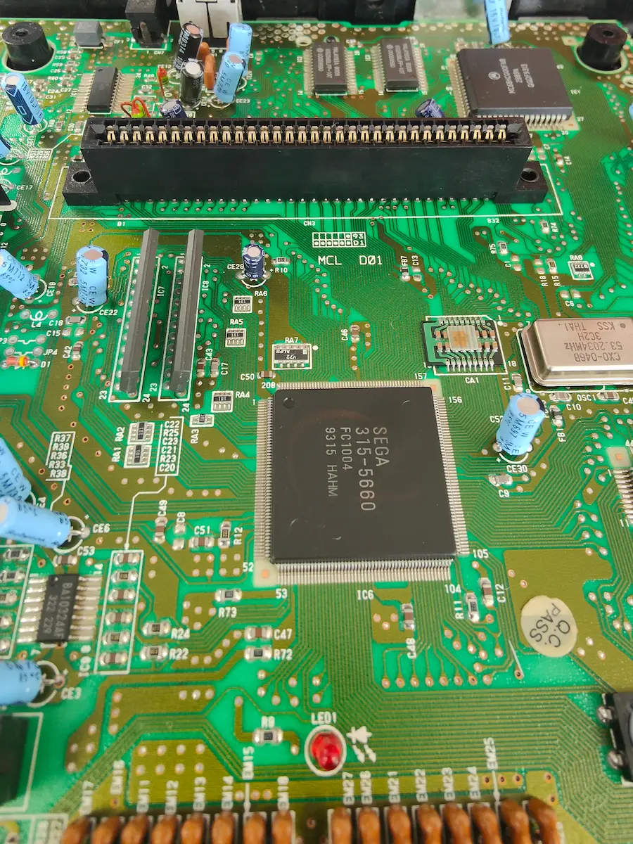Vista general de la placa base de Mega Drive 2 con marcas de humedad